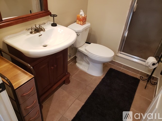A bathroom with a sink, toilet, and a mirror.
