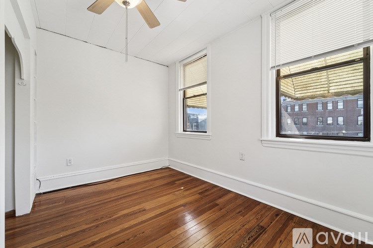 A room with a ceiling fan and a window with blinds.