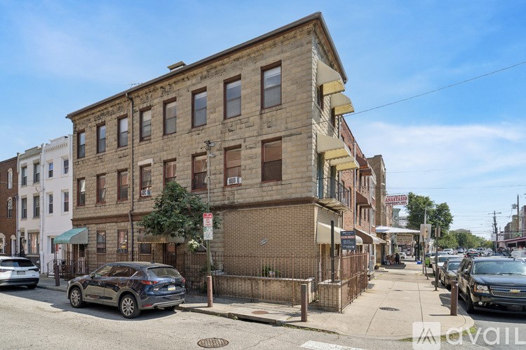 A street view of a row of buildings with cars parked on the side.