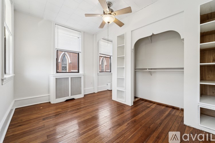 A room with a ceiling fan and wooden floors.