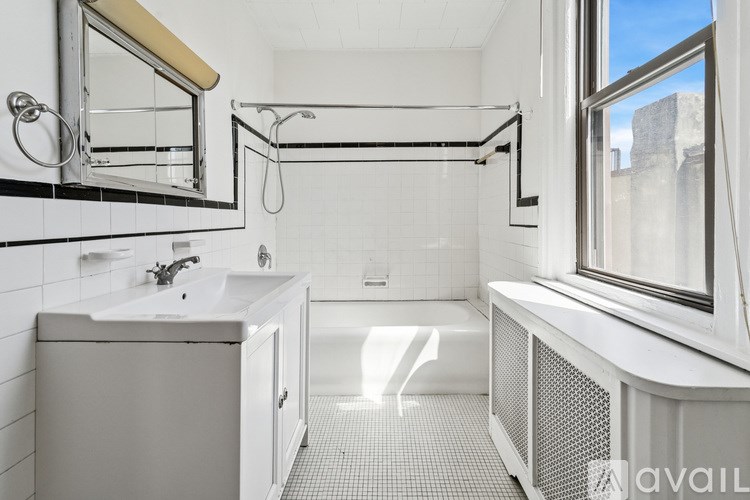 A white bathroom with a shower and a window.