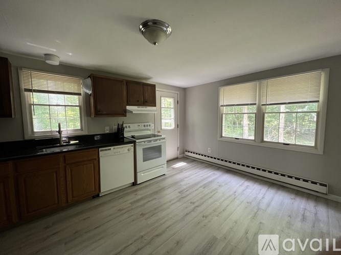 A kitchen with white appliances and wooden cabinets.
