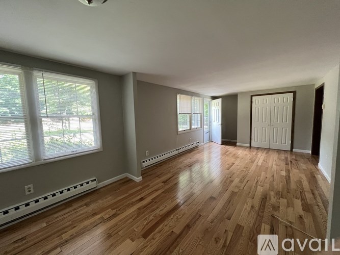 A room with wooden flooring and a sliding door.