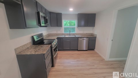 A kitchen with a granite countertop and wooden flooring.