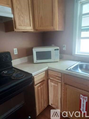 A kitchen with a white microwave on the counter.
