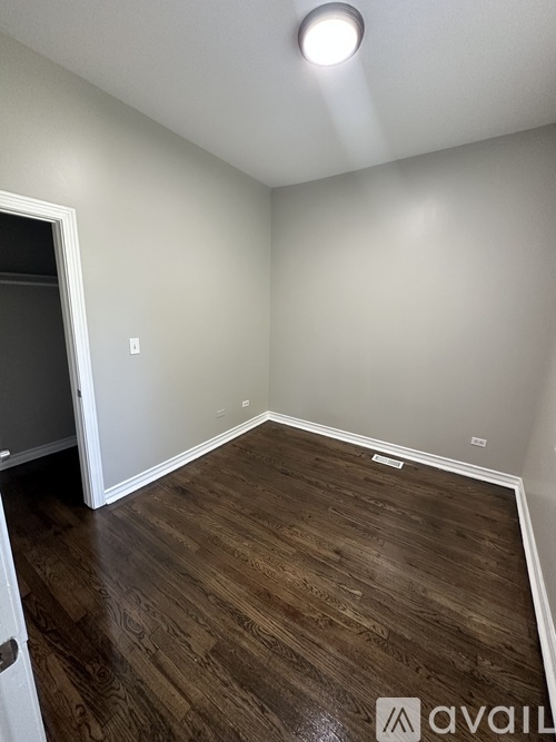 A room with wooden flooring and a white door.