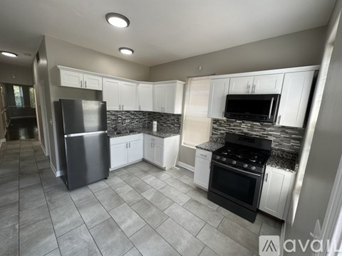 A kitchen with a refrigerator, oven, and cabinets.
