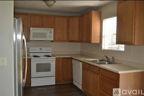 A kitchen with wooden cabinets and white appliances.
