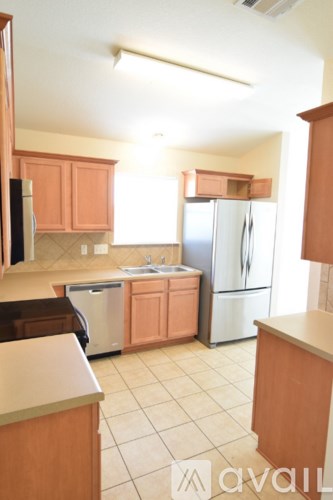 A kitchen with wooden cabinets and a refrigerator.