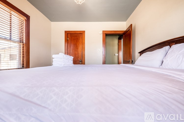 A bedroom with a large bed and two doors.