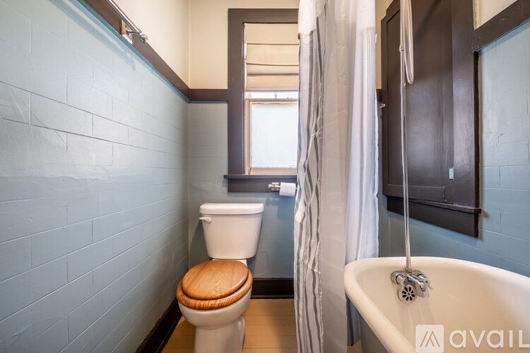 A bathroom with a toilet, a bathtub and a window.