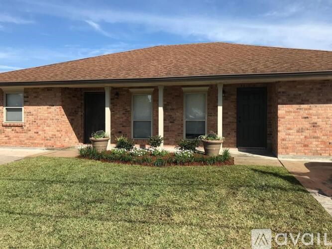 A house with a brick exterior and a well-kept lawn.