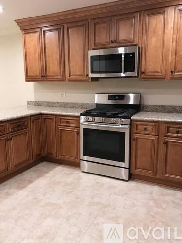 A kitchen with wooden cabinets and a stainless steel stove.