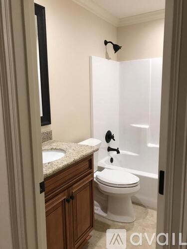 A white toilet is in a bathroom with a walk-in shower.