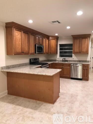 A kitchen with wooden cabinets and a granite countertop.