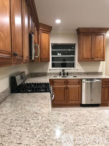 A kitchen with wooden cabinets and granite countertops.