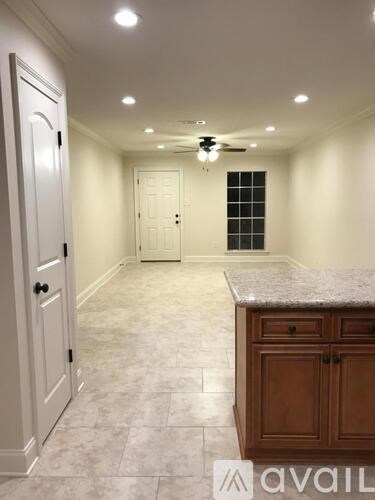 A spacious room with a marble countertop and a ceiling fan.
