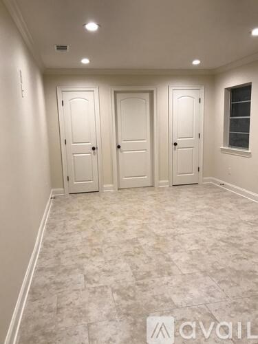 A hallway with three doors and a window.