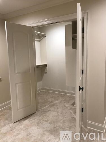 A white door is open to a room with a carpeted floor.