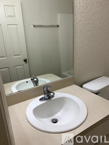 A white sink in a bathroom with a mirror above it.