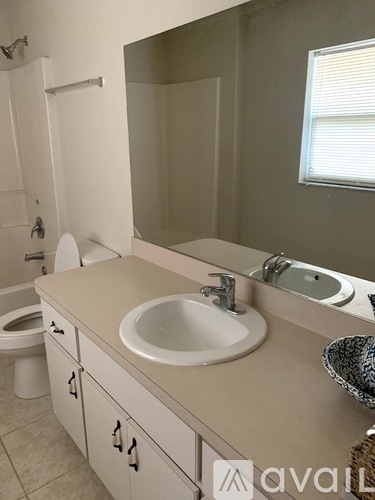 A bathroom with a toilet, sink, and mirror.