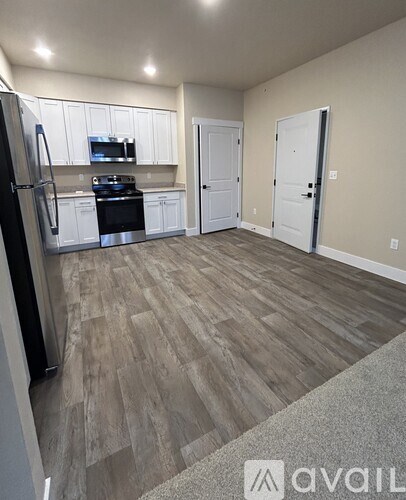 A kitchen with a refrigerator, microwave, oven, and cabinets.