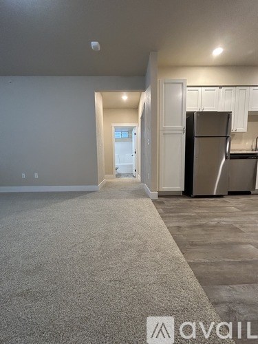A kitchen area with a refrigerator and cabinets.