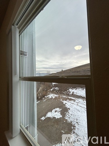 A view of a snowy landscape through a window.