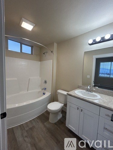 A bathroom with a tub, toilet, and sink.