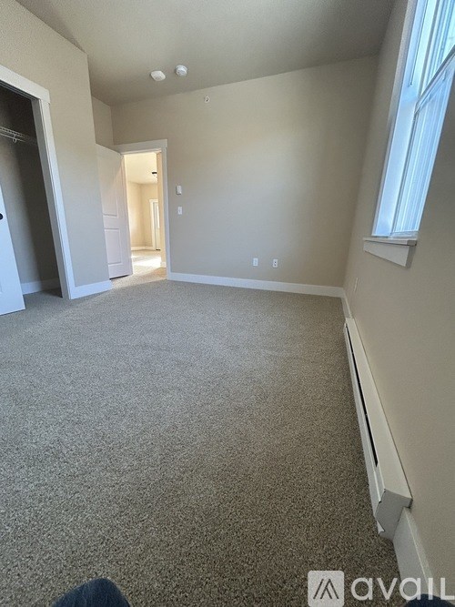 A room with carpeted floor and a window on the wall.