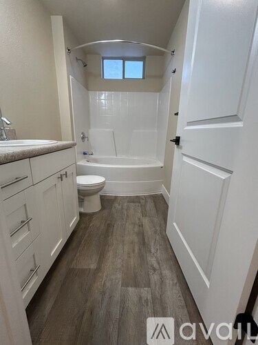 A bathroom with a toilet, sink, and bathtub.