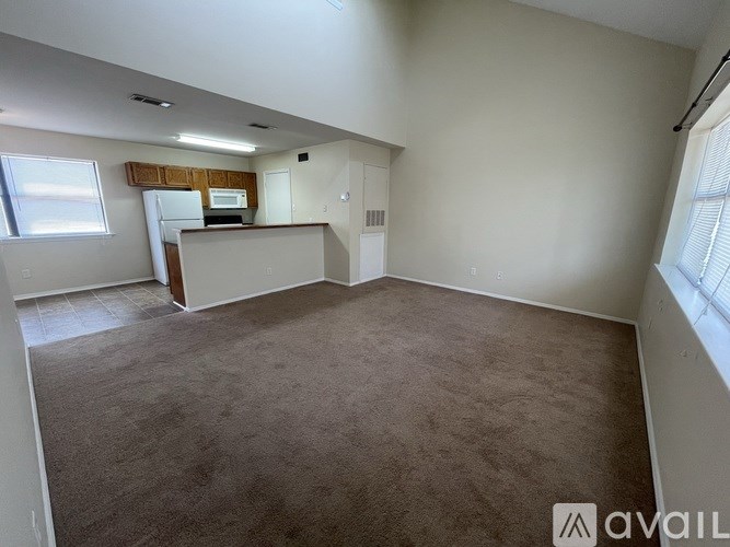 A room with a carpeted floor and a window with blinds.