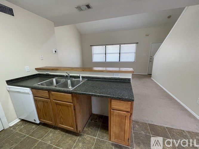 A kitchen with a black countertop and wooden cabinets.