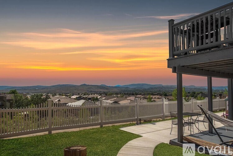 A sunset view from a balcony overlooking a neighborhood.