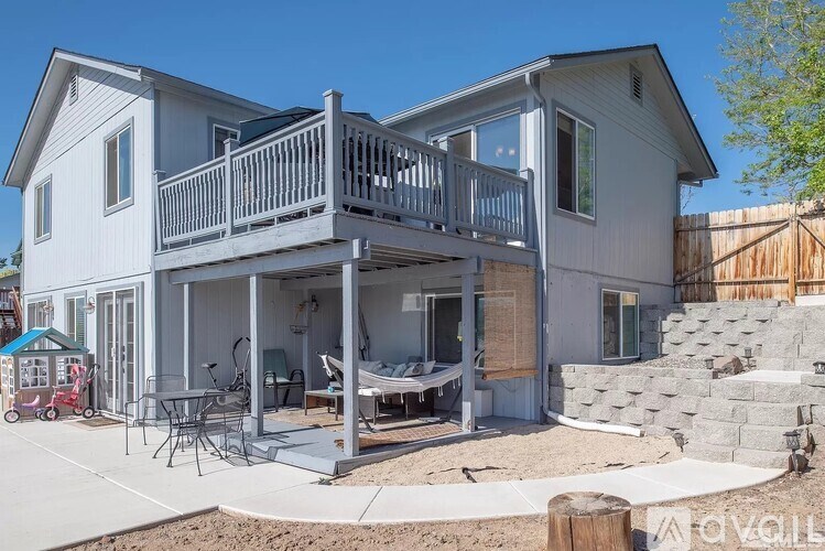 A two-story house with a balcony and a patio area.