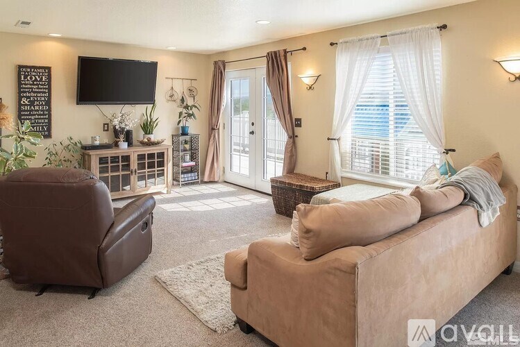 A living room with a brown leather chair and a brown sofa.