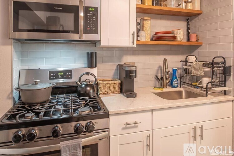 A kitchen with a stove, microwave, and sink.