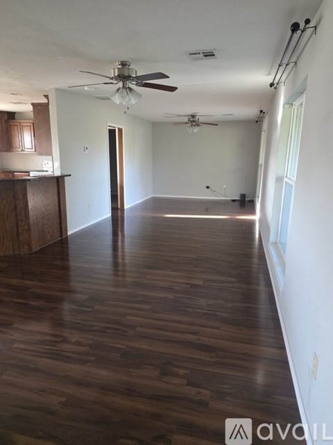 A room with wooden floors and a ceiling fan.