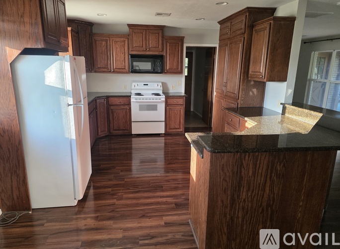 A kitchen with wooden cabinets and a white refrigerator.