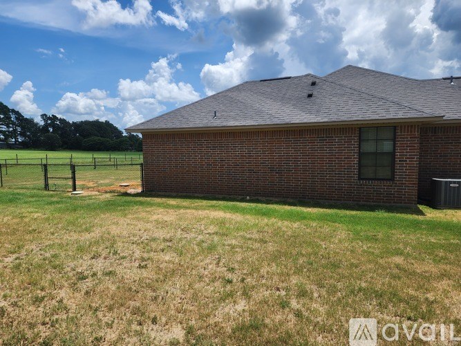 A house with a brown roof and a green lawn in front.