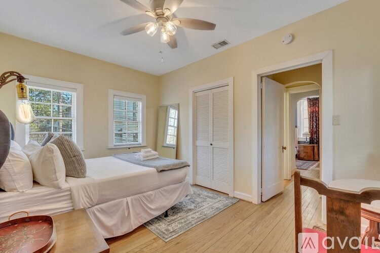 A bedroom with a bed, a chair, and a window.