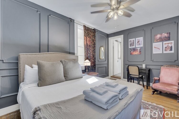 A bedroom with a large bed and a ceiling fan.