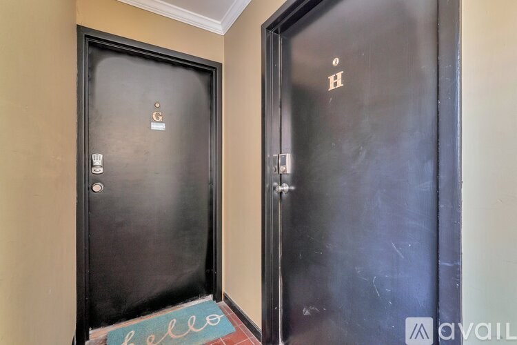 Two black doors with the letter H on the right one.