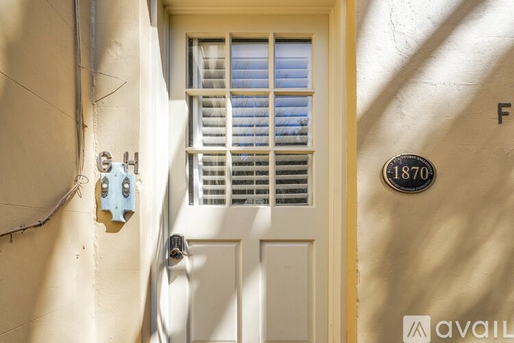 A white door with a window above it and a mailbox on the wall.