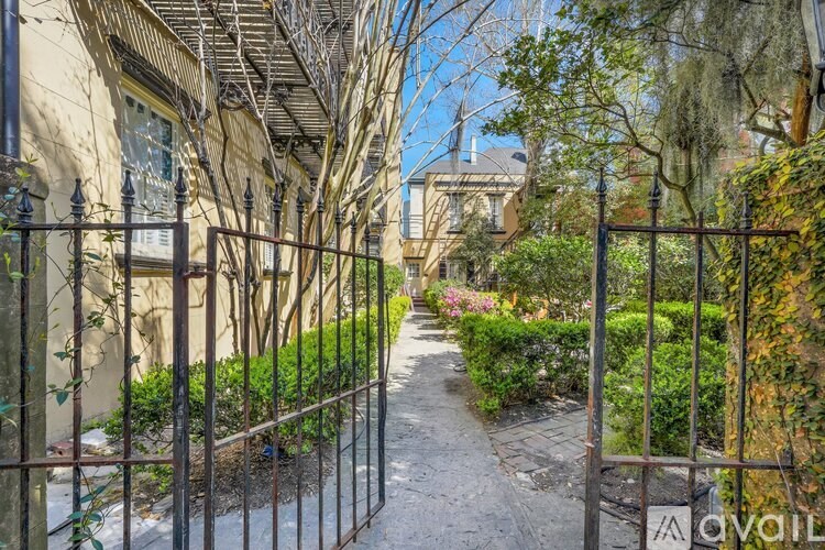 A narrow alley with a metal gate at the end.