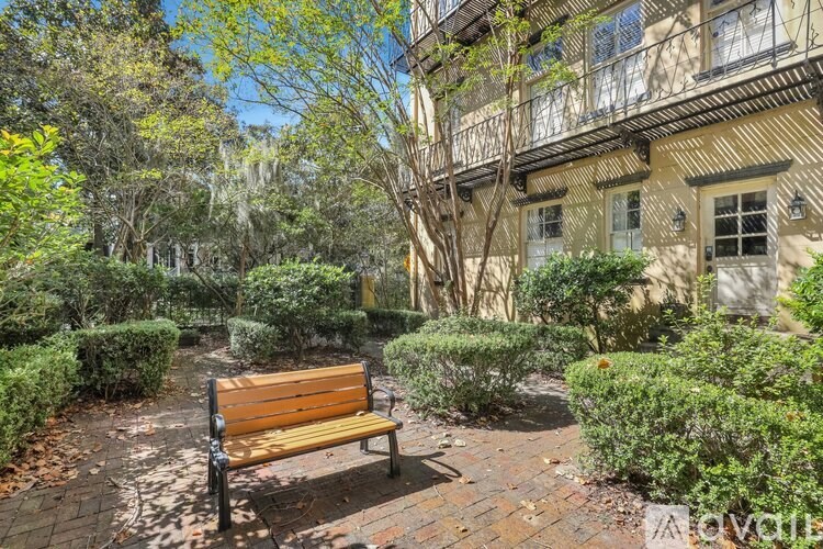 A wooden bench sits in the middle of a brick courtyard.