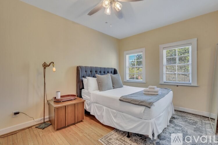 A bedroom with a bed, nightstand, and window.