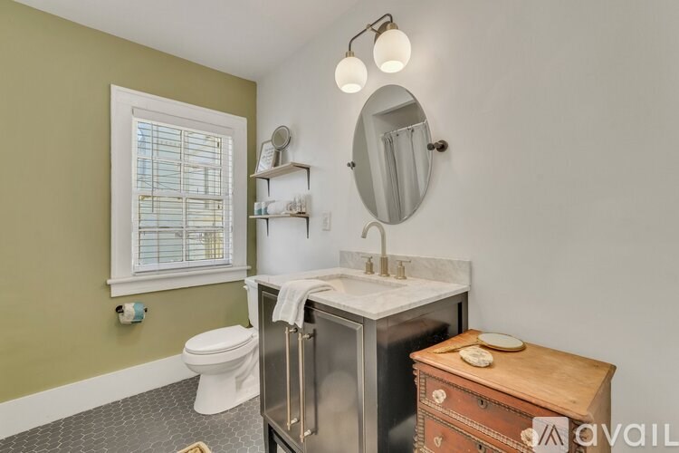 A bathroom with a toilet, sink, and mirror.