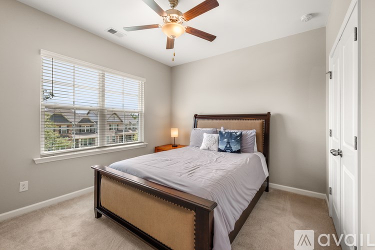 A bedroom with a large bed and a ceiling fan.