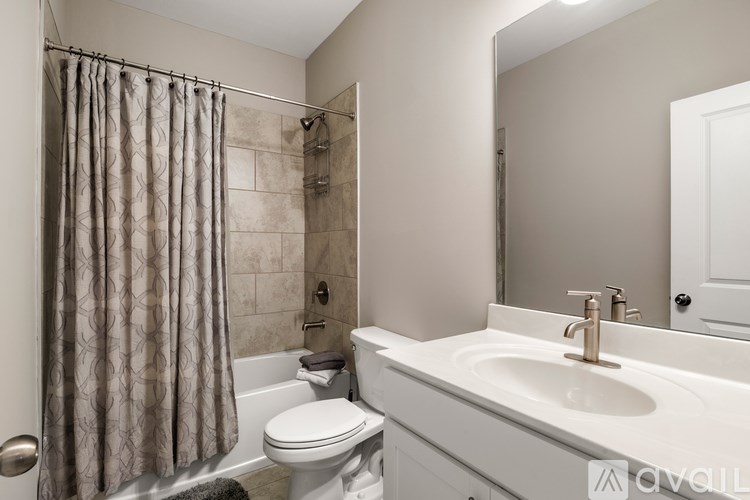 A bathroom with a white toilet, a white sink, and a shower with a curtain.